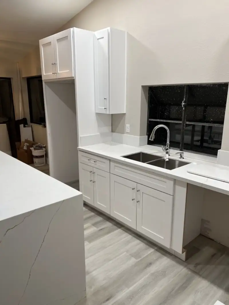Quartz counters with white shaker cabinets and an undermount sink