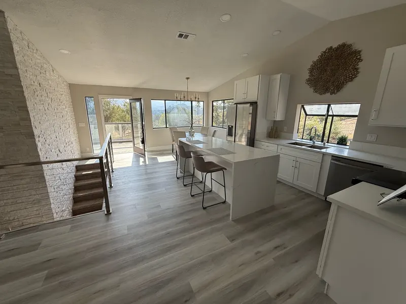Island kitchen open to a dining area with deck doors